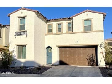 Inviting two-story home featuring a well-manicured lawn, arched door and a two car garage at 6437 N 17 St, Phoenix, AZ 85016