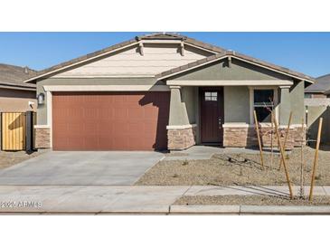 Single-story home with brown garage door, stone accents, and landscaping at 16014 W Cottontail Ln, Surprise, AZ 85387
