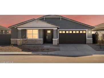 Gray house with brown garage door, stone accents, and landscaping at 36933 W La Paz St, Maricopa, AZ 85138