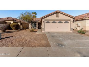 Single-story house with a two-car garage and desert landscaping at 574 W Kingman Dr, Casa Grande, AZ 85122