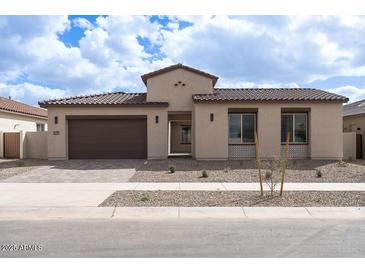 Charming single-story home featuring a tile roof, desert landscaping, and a two-car garage at 829 W Golden Ore Pass, Apache Junction, AZ 85120