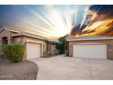 Charming home featuring a stone and stucco facade, with a large driveway and well-maintained landscaping at 2116 N 81St Cir, Mesa, AZ 85207