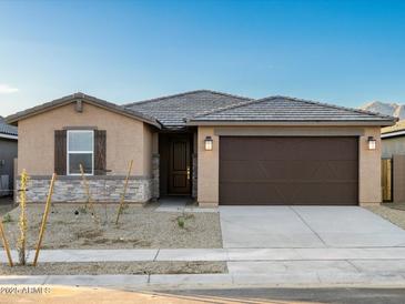 Charming single-story home features a brown two-car garage and a low maintenance gravel front yard at 22455 W Pontiac Dr, Surprise, AZ 85387