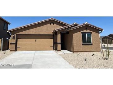 Single-story home featuring an attached two-car garage, a neutral color scheme, and minimal landscaping at 24592 W St Anne Ave, Buckeye, AZ 85326