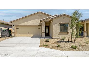 Beige one-story home with a two-car garage, desert landscaping and neutral trim at 24592 W St Anne Ave, Buckeye, AZ 85326