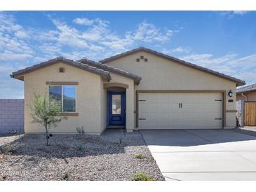 Charming single-story home with desert landscaping, a two-car garage, and a welcoming blue front door at 24593 W St Catherine Ave, Buckeye, AZ 85326