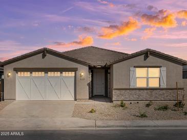 Charming single-story home featuring a two-car garage and professionally landscaped front yard at 37014 W La Paz St, Maricopa, AZ 85138