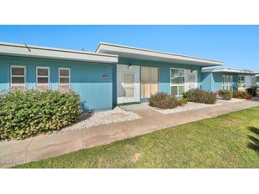 Charming blue single-story home with a well-maintained lawn and manicured landscaping at 10026 W Lancaster Dr, Sun City, AZ 85351