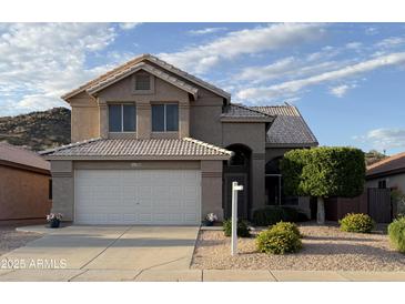 Charming two-story home with a well-manicured front yard and a two-car garage in a suburban neighborhood at 1926 E Siesta Ln, Phoenix, AZ 85024