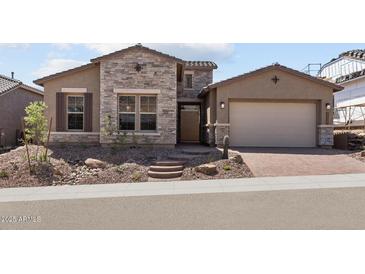 Charming single-Gathering home featuring a stone facade, desert landscaping, and a two-car garage at 32513 N 135Th Dr, Peoria, AZ 85383