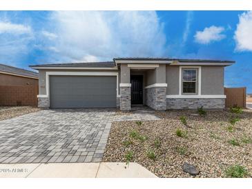 Charming single-story home features a gray brick driveway and stucco exterior with stone accents at 18605 E Panchito Dr, Gold Canyon, AZ 85118