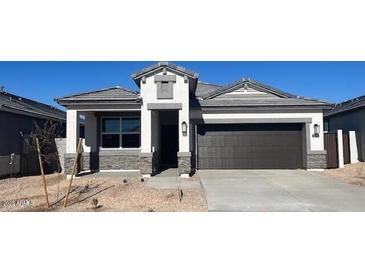 Single-story home with gray roof and dark garage door at 25388 W Sunland Ave, Buckeye, AZ 85326