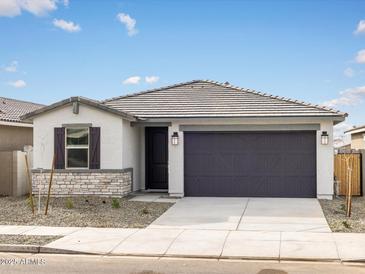 Charming single-story home with a two-car garage, stone accents, and desert landscaping at 16017 W Cottontail Ln, Surprise, AZ 85387
