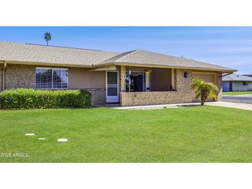 Charming single-story home with a well-maintained lawn and inviting front porch, situated on a sunny corner lot at 9902 W Sandstone Dr, Sun City, AZ 85351
