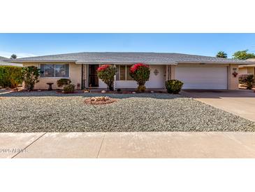 Ranch-style home with landscaped yard and attached garage at 9409 W Glen Oaks N Cir, Sun City, AZ 85351