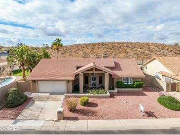Charming single-story home featuring a tile roof, two-car garage, and low-maintenance desert landscaping at 1017 E Grandview Rd, Phoenix, AZ 85022