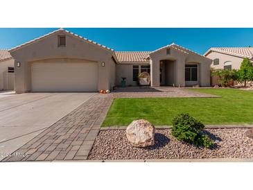Charming single-story home featuring a well-manicured lawn and tile roof at 22364 N 67Th Dr, Glendale, AZ 85310