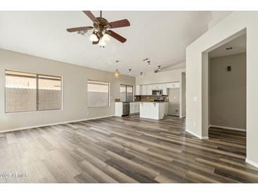 Open-concept living space with gray vinyl floors, neutral color palette, and seamless flow into the kitchen area at 6658 E San Cristobal Way, Gold Canyon, AZ 85118