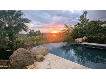 Stunning pool with city sunset views and natural rock accents at 4836 E White Gates Dr, Phoenix, AZ 85018