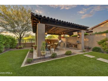 Outdoor patio with fireplace, built-in BBQ, and seating area at 3219 S Silverberry Ct, Gold Canyon, AZ 85118