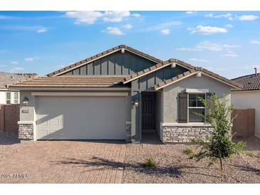 Charming single-story home with a brick driveway, two-car garage, and stylish stone accents at 4107 E Ghost Flower Ln, San Tan Valley, AZ 85140