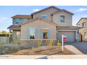 Two-story house with gray siding, stone accents, and a landscaped front yard at 5923 N 83Rd Ln, Glendale, AZ 85305