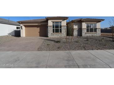 Beautiful single-Gathering home boasts a two-car garage, stone veneer accents, and a well-maintained front yard at 6829 N 190Th Dr, Waddell, AZ 85355