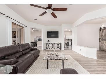 Bright living room boasts hardwood floors, a ceiling fan, and neutral-colored walls at 520 S Brett St, Gilbert, AZ 85296