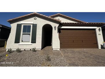 Charming single-story home showcasing a well-manicured front yard and a two-car garage at 21565 N Rummler Ln, Maricopa, AZ 85138