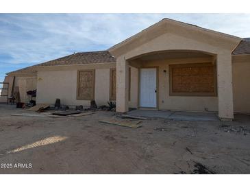 Newly constructed house with a covered porch and unfinished landscaping at 37909 W Raymond St, Tonopah, AZ 85354