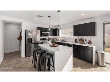Bright kitchen with stainless steel appliances, a waterfall island, and black cabinetry at 8913 E Oro Cir, Mesa, AZ 85212