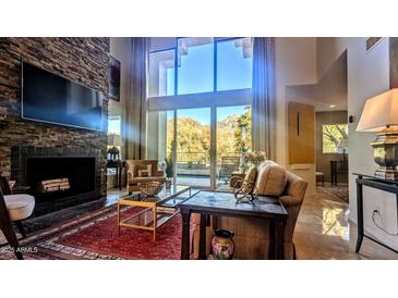 Spacious living room with stone fireplace, large windows, and mountain views at 3010 E Sierra Vista Dr, Phoenix, AZ 85016