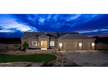 Stunning single-story home with a three-car garage and desert landscaping set against a striking twilight sky at 300 W Quartz Rock Rd, Phoenix, AZ 85085