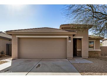 One-story house with tan colored exterior and a two-car garage at 5411 W Grenadine Rd, Laveen, AZ 85339