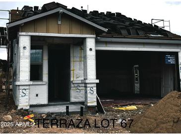 New construction shows in this elevation with an unfinished exterior, showing the roof partially shingled and covered porch at 5664 N 205Th Ln, Buckeye, AZ 85396