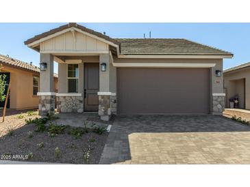 Charming single-story home with stone accents, covered entry, and two-car garage at 5664 N 205Th Ln, Buckeye, AZ 85396