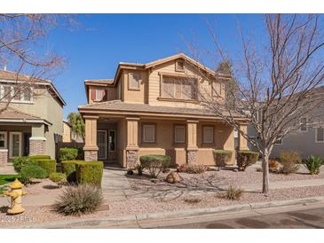 Tan two-story home featuring desert landscaping and covered porch entry with stone-accented columns at 4130 W Irwin Ave, Phoenix, AZ 85041