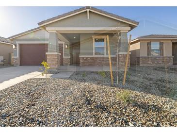 Charming home featuring stone accents, desert landscaping, and a covered front porch at 16005 W Cottontail Ln, Surprise, AZ 85387