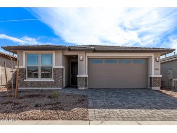 Charming single-Gathering home featuring a two-car garage, desert landscaping, and a brick-accented facade at 40005 W Elm Dr, Maricopa, AZ 85138