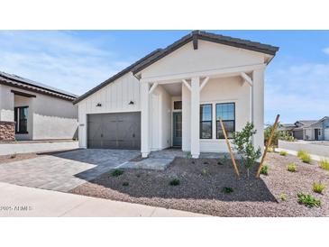 Charming single-story home featuring a grey roof, well-manicured yard and stylish modern farmhouse architecture at 4405 N 203Rd Ave, Buckeye, AZ 85396