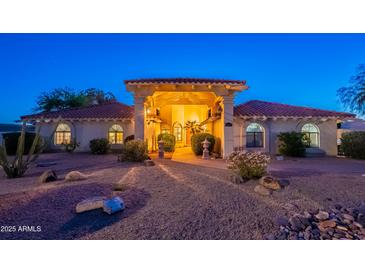 Charming home featuring a desert landscape, covered entry and a red tile roof, illuminated in the evening at 13108 N 76Th St, Scottsdale, AZ 85260