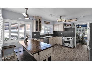 Modern kitchen features stainless steel appliances, dark countertops, and a rustic island, creating a chef's dream space at 1820 N 7Th Ave, Phoenix, AZ 85007