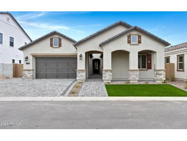 Charming single-story home with a two-car garage, arched entryway, and well-manicured front yard at 3624 N 59Th St, Mesa, AZ 85215