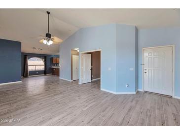 Bright living room with vaulted ceiling, tile floors, and access to backyard at 42473 W Sparks Dr, Maricopa, AZ 85138