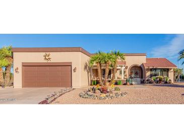 Beautiful desert landscaping surrounds this one-story home with a large garage at 13418 W Stardust Blvd, Sun City West, AZ 85375