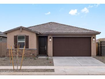 Charming single-story home with a stone-accented facade, a two-car garage, and a well-manicured front yard at 15995 W Cottontail Ln, Surprise, AZ 85387