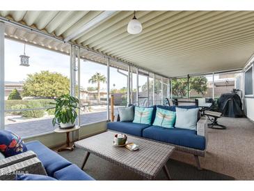 Relaxing screened patio with wicker furniture and view of backyard at 10714 W Willowbrook Dr, Sun City, AZ 85373