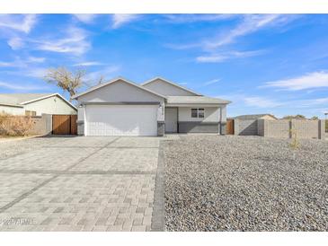 Charming single-story home showcasing desert landscaping and a two car garage at 10810 W Torren Dr, Arizona City, AZ 85123