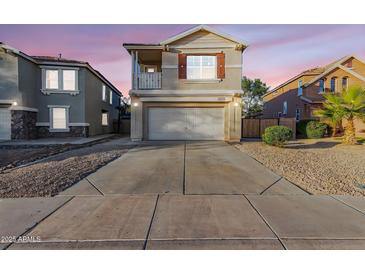 Charming two-story home with a large driveway and a small second story balcony at 14862 W Laurel Ln, Surprise, AZ 85379