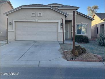 Tan one-story house with a two-car garage and desert landscaping at 805 W Sunset Dr, Coolidge, AZ 85128